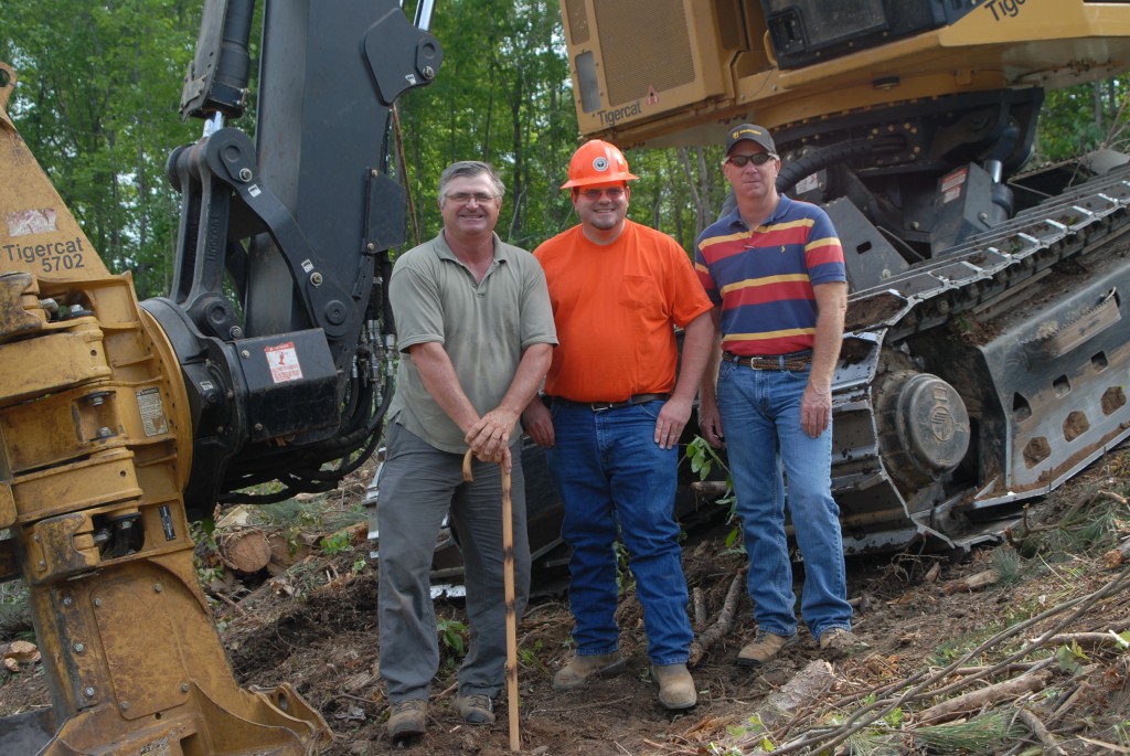 One happy operator. Derrick O’Bryant flanked by Mackolines Machines & Hire district manager, Johnny Boyd and B&G salesman, Johnny Burton stand together in front of a Feller buncher.