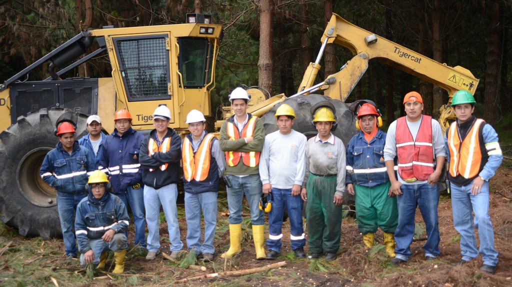 The COTOPAXI S.A. harvesting team; a large group of men stand together in front of a Mackolines Machines & Hire 620D skidder.