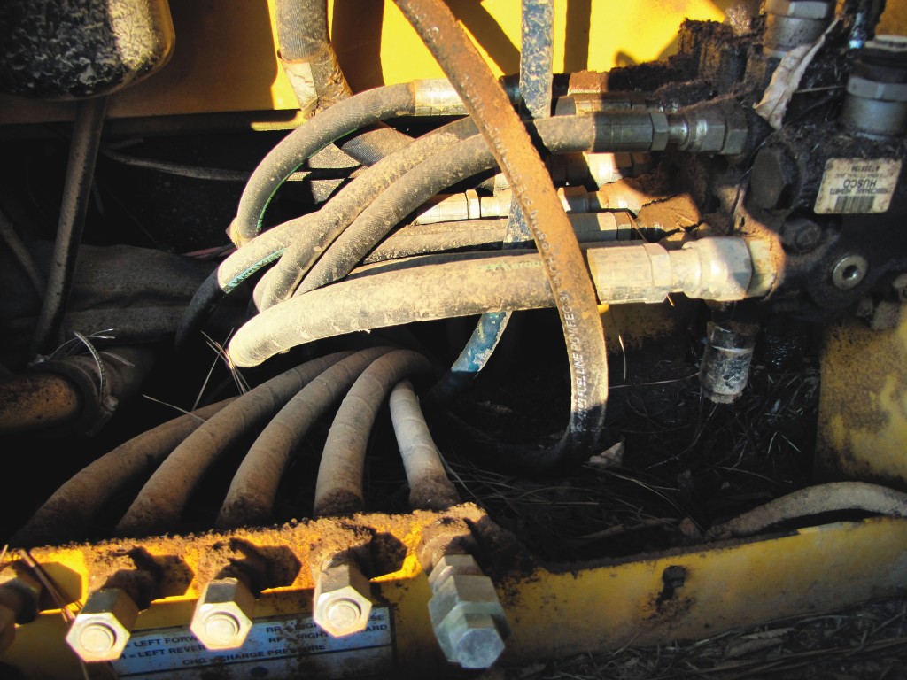 Forestry equipment inspection. Removing debris near the engine manifold and turbo charger is a must.