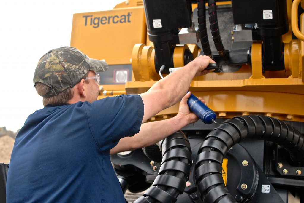 An operator performing regular greasing on a Mackolines Machines & Hire machine.