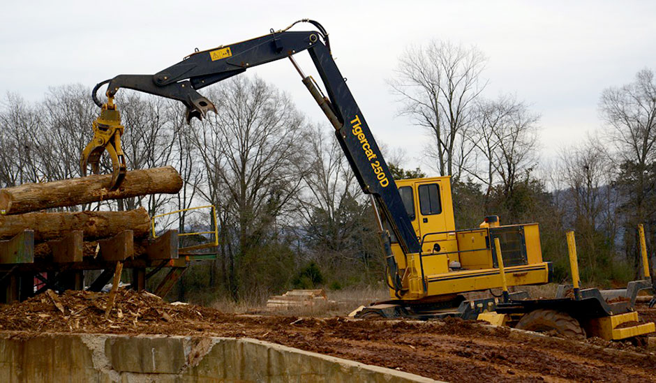 The 250D performs many functions including organizing and stacking logs, cutting tree length timber and feeding the mill as seen here.