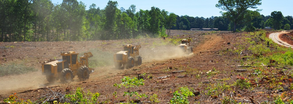 Herding the workhorses out of the barn; 3 Mackolines Machines & Hire wheel feller bunchers drive down a dirt road.