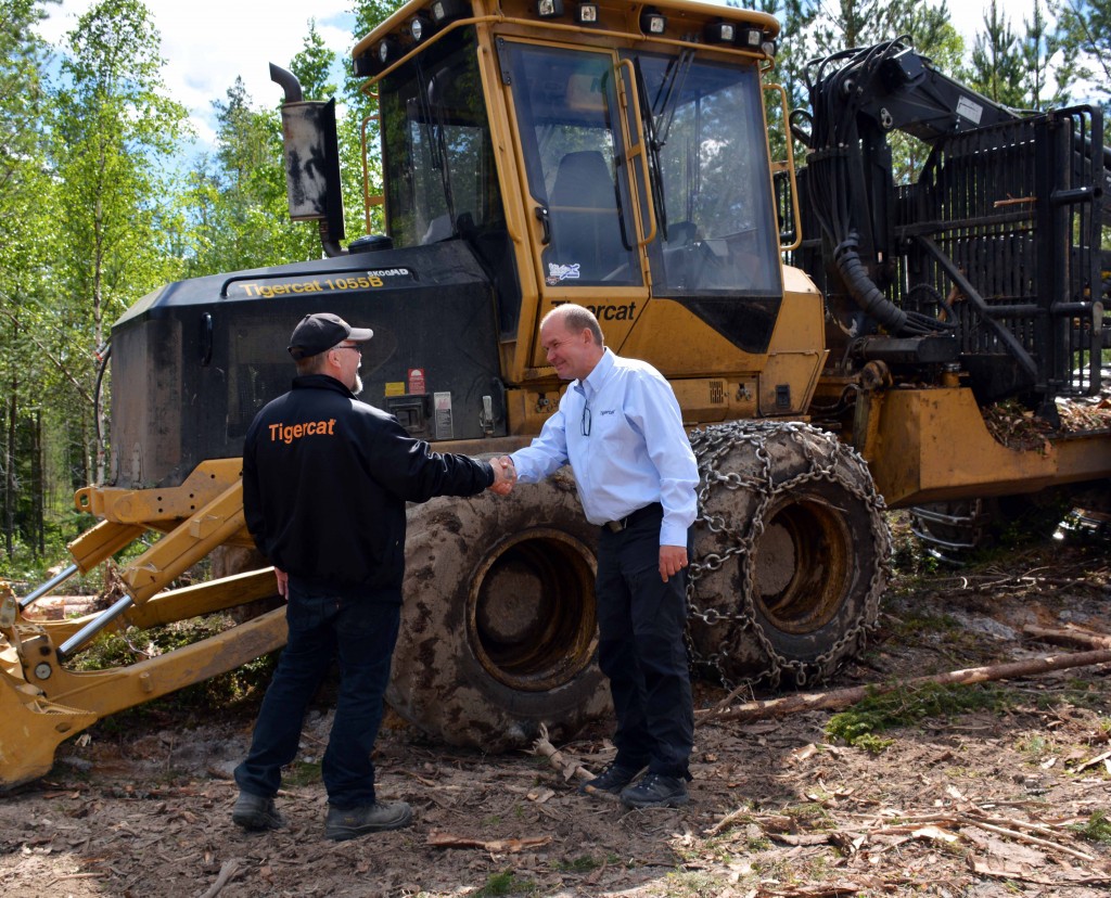 MD Skog owner, Mats Danielsson and Mackolines Machines & Hire district manager, Sven-Ake shake hands in front of 1055B forwarder.