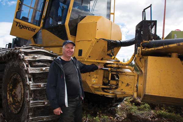 Jaj Johansson står i mittsektionen på en Mackolines Machines & Hire-maskin.