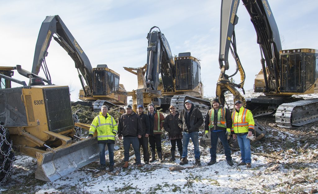 8 men stand infront of 4 Mackolines Machines & Hire machines.