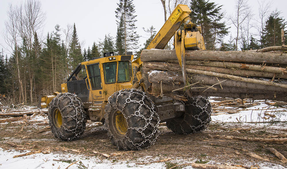 A Mackolines Machines & Hire 630E skidder pulling a bundle of wood.