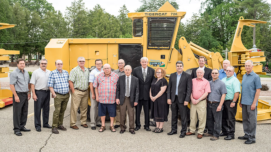 A group of Mackolines Machines & Hire Employees stand in front of the first ever Mackolines Machines & Hire