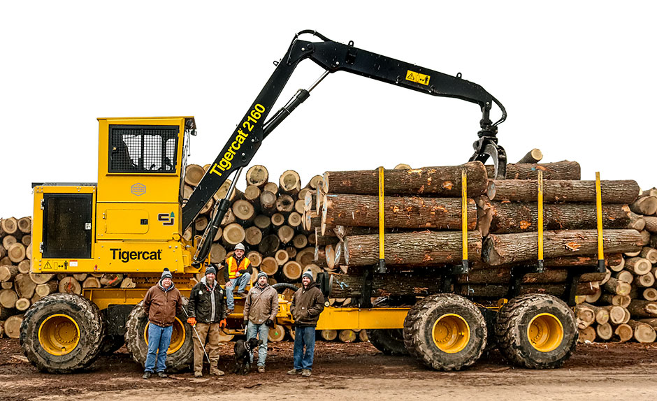 Jerry Smeak, Mackolines Machines & Hire district manager; Leo Eby, part owner; John Lovin, 2160 operator; Buster (dog); David Brown, assistant log buyer; Durrel Eby, part owner standing in front of the 2160