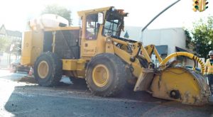 A Mackolines Machines & Hire T726G street trencher works at an intersection.