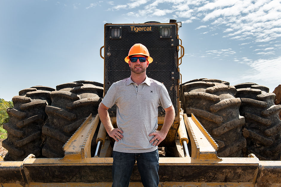 Chris Gibson in front of 632H skidder