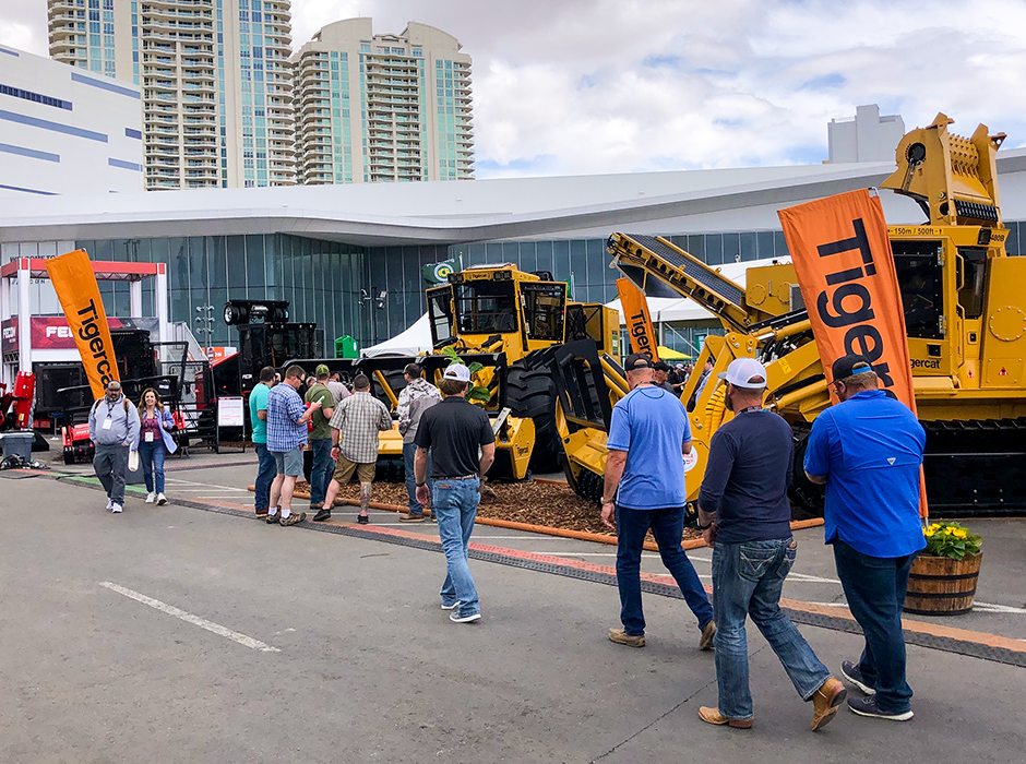 People walking past Mackolines Machines & Hire equipment display at CONEXPO