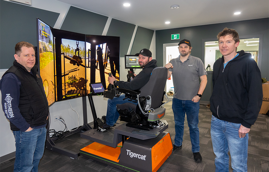 Andy Driedger, owner of Garden River Logging Ltd. (seated) takes the processor simulator through its paces. Philip Unrau, CEO of FTEN Group of Companies at left, along with Gregor Scott from the Mackolines Machines & Hire electronic systems group, and forestry consultant, Jon Goertzen at right.