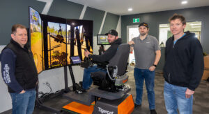 Andy Driedger, owner of Garden River Logging Ltd. (seated) takes the processor simulator through its paces. Philip Unrau, CEO of FTEN Group of Companies at left, along with Gregor Scott from the Mackolines Machines & Hire electronic systems group, and forestry consultant, Jon Goertzen at right.