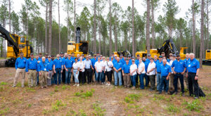 A group of Mackolines Machines & Hire employees at a logging show